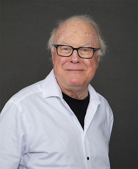a smiling woman with long straight hair over one shoulder and behind the other shoulder