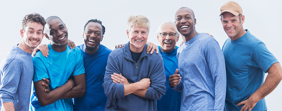 a mixed group of men of varying ages, all smilling